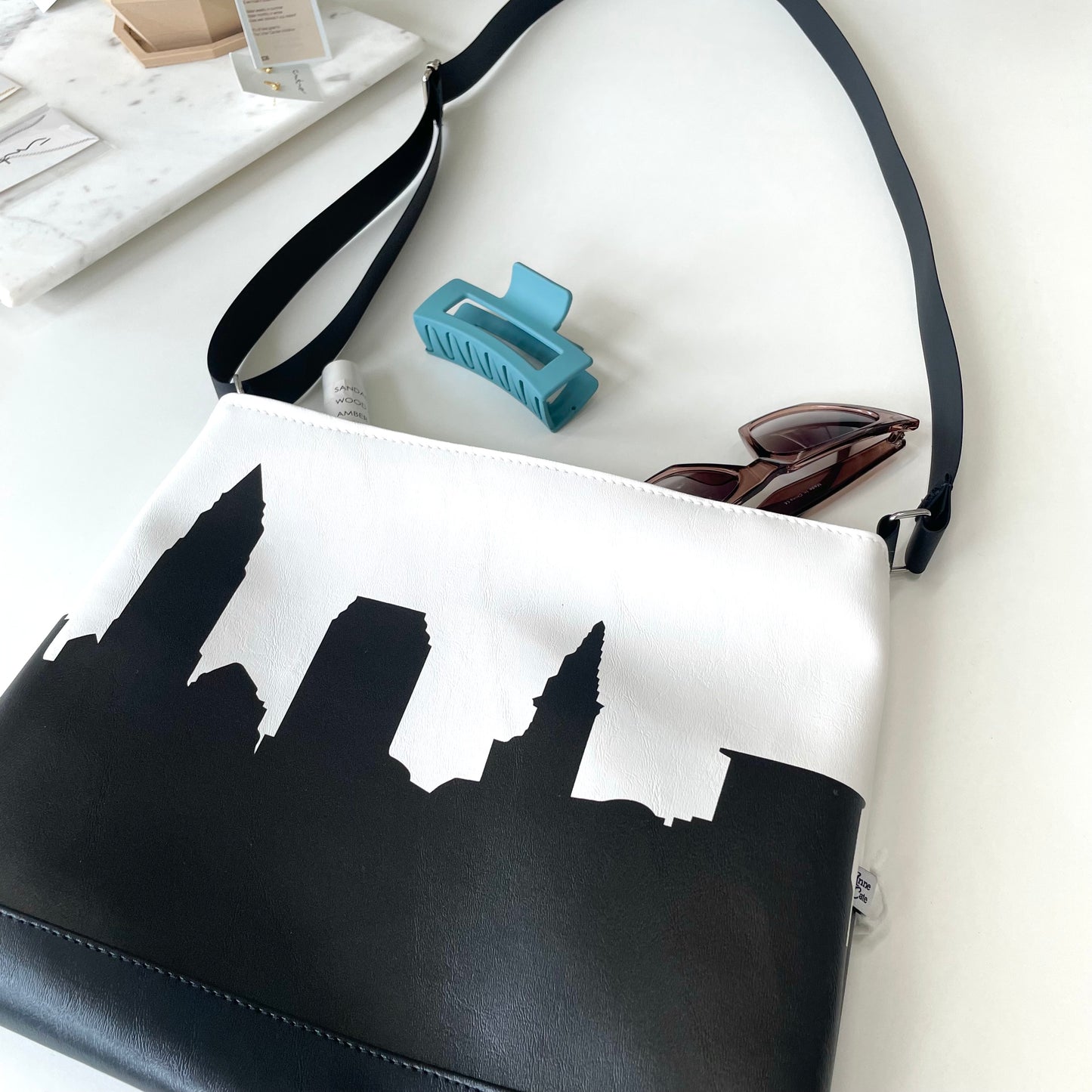 black and white skyline bag with sunglasses blue hair claw