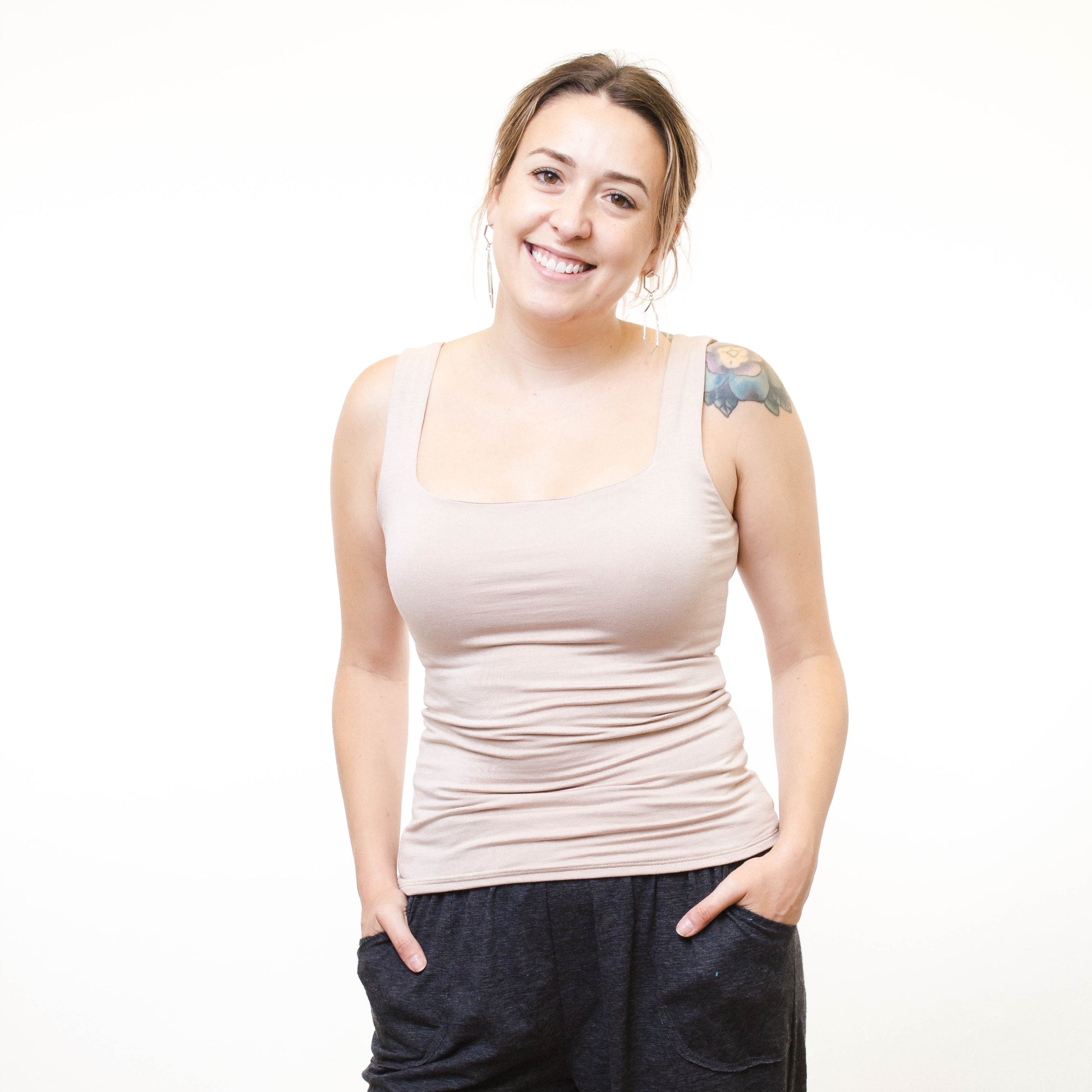 lady wearing light taupe basic tank top hands in pockets